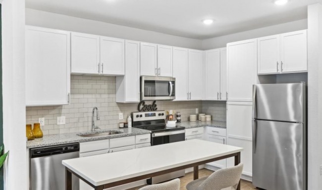 Settle into comfort at Residences at Markets West a kitchen with white cabinets